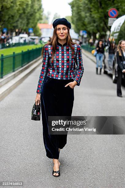 Gala Gonzalez wears hat, checkered red blue jacket, velvet pants, black bag outside Armani during the Milan Fashion Week Womenswear Spring/Summer...