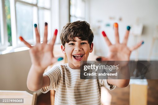 Boy smiling at camera with painted hands Boy smiling at camera with painted hands