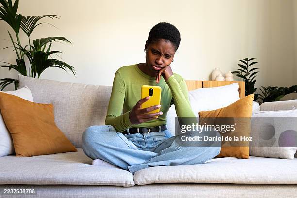 young woman feeling surprised and annoyed reacting to smartphone - verward stockfoto's en -beelden