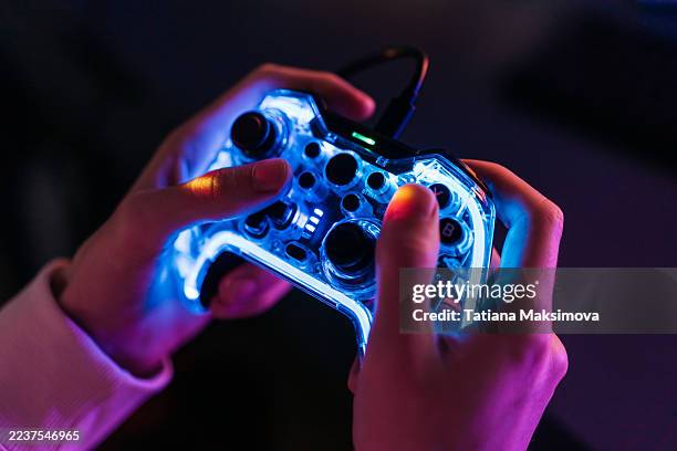 a man with a neon joystick in the dark playing video game on a computer. - videospel stockfoto's en -beelden