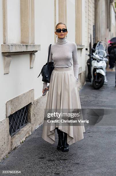 Caroline Daur wears grey turtleneck, creme white pleated skirt, black bag outside Tods during the Milan Fashion Week Womenswear Spring/Summer 2026 on...