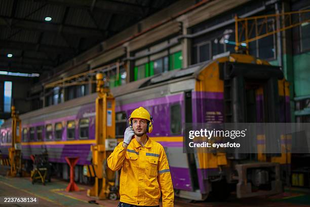 blue collar worker is working at train garage. - public transportation stock pictures, royalty-free photos & images