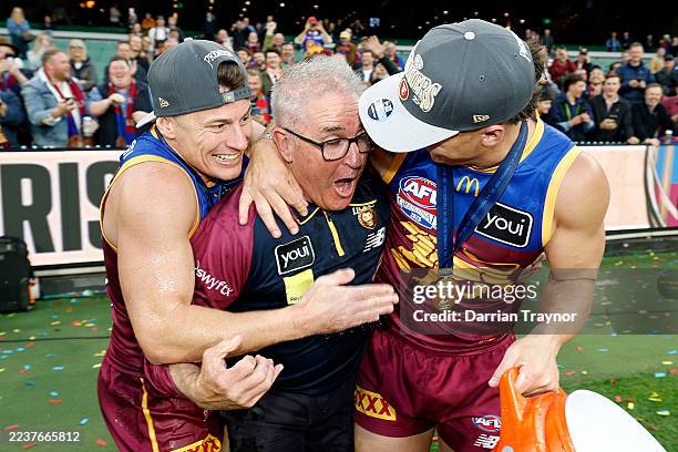 Dayne Zorko of the Lions and Cam Rayner of the Lions dunk Chris Fagan, Coach of the Lions with gatorade following winning the 2025 Premiership during...
