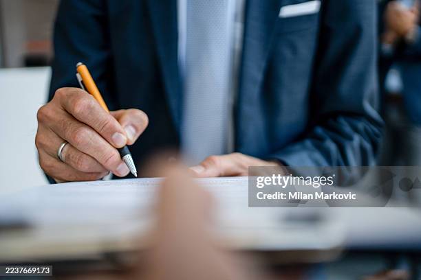 uomo d'affari che firma un contratto legale, chiudendo un affare - costituzione foto e immagini stock
