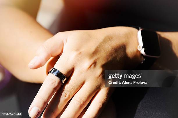 woman wearing smart ring on her hand. concept sport and healthy lifestyle - wearable stock-fotos und bilder