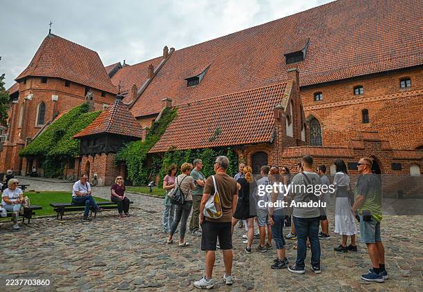 Group of tourists exploring the Middle Castle section of Malbork Castle, in Malbork, Pomeranian Voivodeship, Poland, on September 3, 2025. Built in...