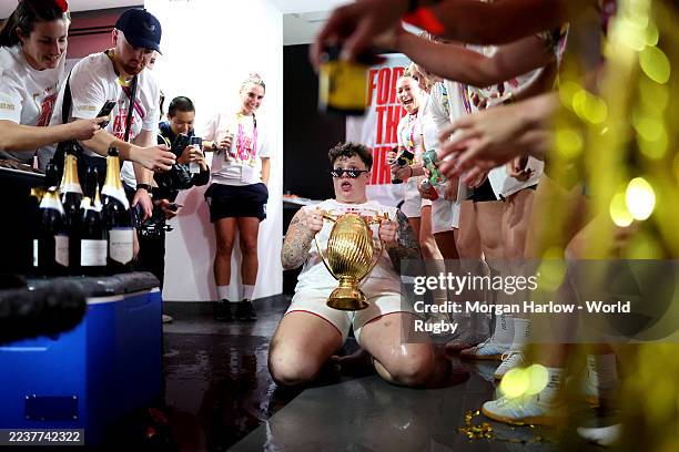 Hannah Botterman of England celebrates with the Women's Rugby World Cup trophy inside the dressing room following the team's victory in the Women's...