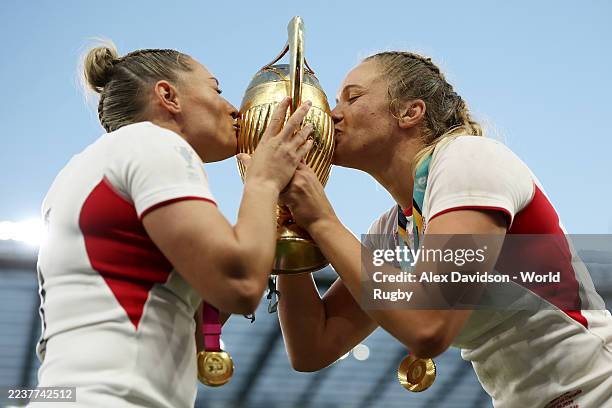 Natasha Hunt and Zoe Aldcroft of England kiss the trophy as they celebrate victory following the Women's Rugby World Cup 2025 Final match between...