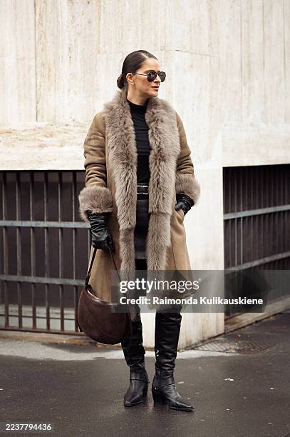Gili Biegun wears suede and shearling fur coat, over the knee black leather boots by AGL, brown suede bag by ATP, long black leather gloves, black...