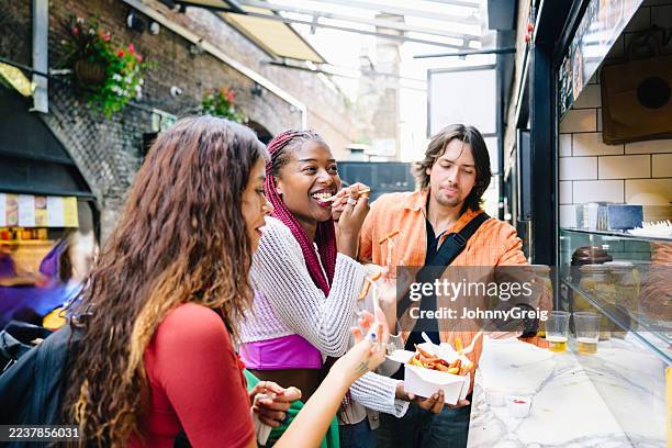donna, degustazione, cibo, da, mercato, con, due, amici, camden, londra - cucina del medio oriente foto e immagini stock