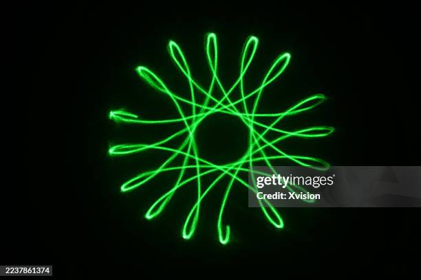 laser light luminous spirograph pattern—a complex web of perfect geometric curves and loops. - laser pointer stock pictures, royalty-free photos & images