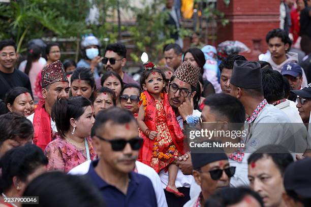 Aryatara Shakya, two and a half years old, in red regalia, is carried by her father as she is brought to the Taleju Bhawani Temple in Kathmandu...