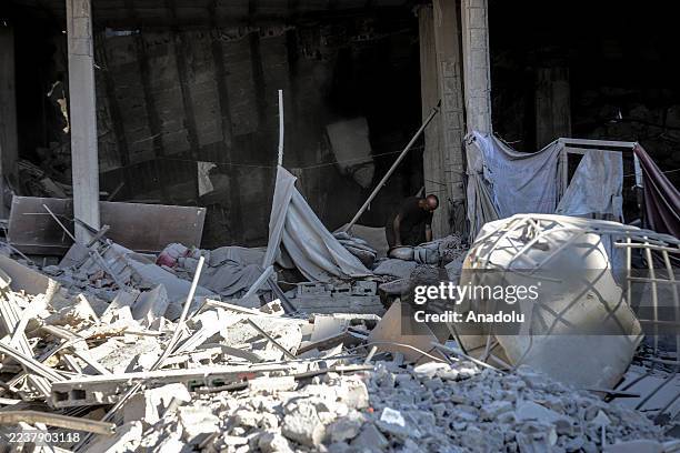 Palestinians search their belongings among the rubble of buildings destroyed by an Israeli attack on Abu Hasira street in Gaza City, Gaza on...