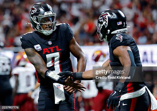 Bijan Robinson of the Atlanta Falcons celebrates a touchdown with Michael Penix Jr. #9 of the Atlanta Falcons during the second quarter against the...