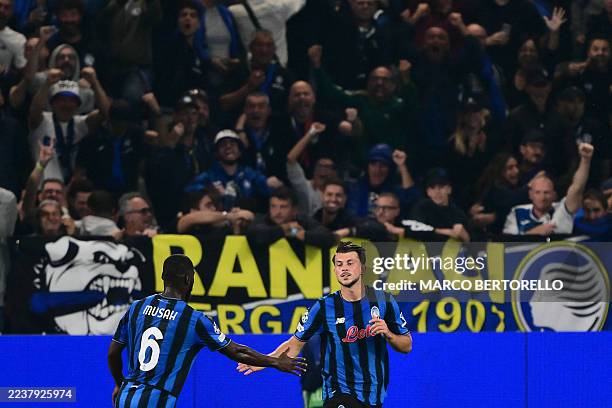 Atalanta's Serbian midfielder Lazar Samardzic celebrates with teammate Atalanta's US midfielder Yunus Musah after scoring a penalty during the UEFA...