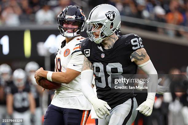 Caleb Williams of the Chicago Bears smiles at Maxx Crosby of the Las Vegas Raiders during the third quarter at Allegiant Stadium on September 28,...