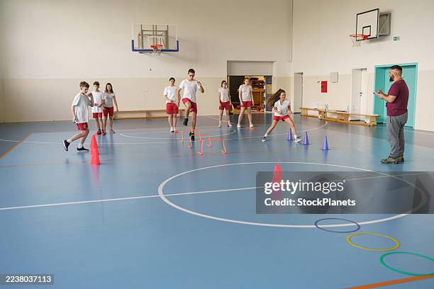 students training agility drills in high school gym. - physical education stock pictures, royalty-free photos & images