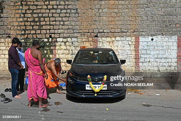 Hindu priest performs a ritual on a newly purchased car on the occasion of Dussehra-Vijaya Dashami festival outside a temple in Hyderabad on October...
