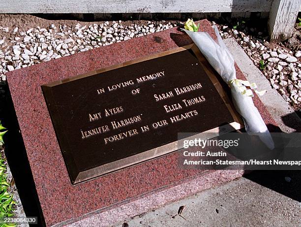 Newly placed yellow rose sits on the memorial for the four victims of the Yogurt shop murders on Anderson Lane.