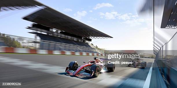 un coche de carreras cruza la línea de meta por delante de su compañero de equipo - circuito de carreras de coches fotografías e imágenes de stock