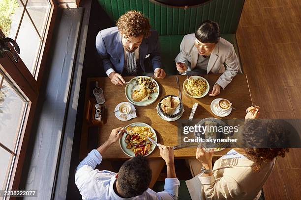 vista sopra, di colleghi felici che pranzano in un ristorante. - pausa pranzo foto e immagini stock
