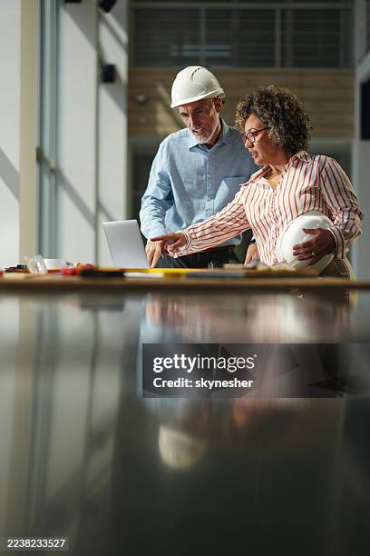project managers working on laptop at construction site. - real estate developer stock pictures, royalty-free photos & images