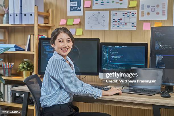 asian woman programmer smiling while coding in office - api developer stock pictures, royalty-free photos & images