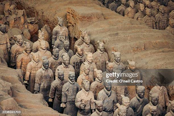 terracotta warriors in rows within a clay excavation site in xi'an, china - terracotta soldiers stock pictures, royalty-free photos & images
