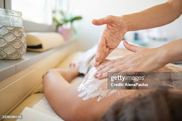 naturheilkundliche massage mit honig - auf rücken liegen stock-fotos und bilder