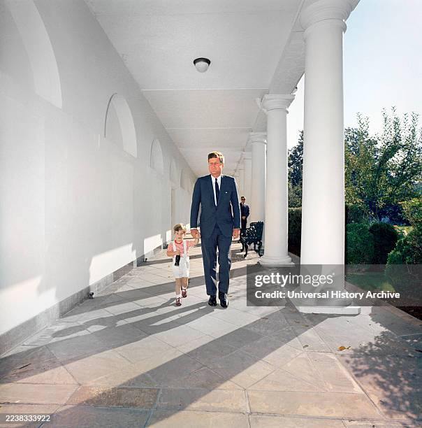 President John F. Kennedy walking with his son, John F. Kennedy, Jr. , along West Wing Colonnade of White House, Washington, D.C., USA, Robert...