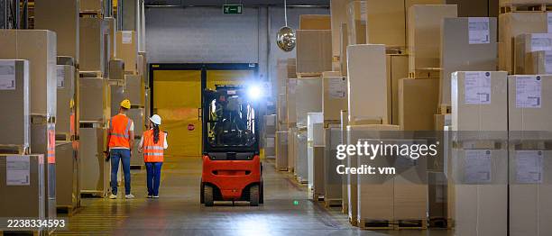warehouse workers and forklift in storage aisle - loading dock stock pictures, royalty-free photos & images