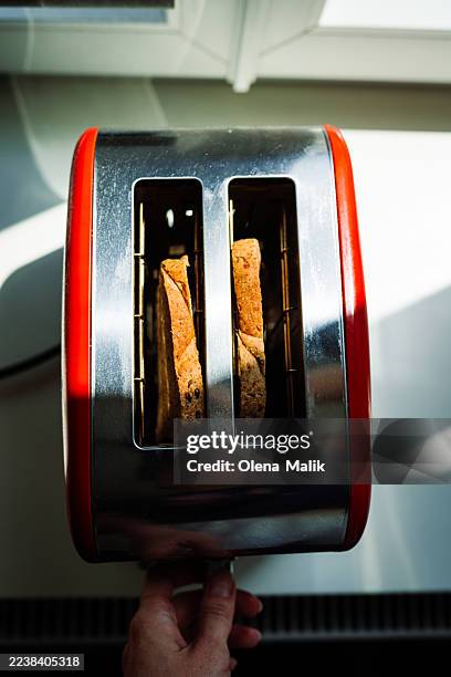 red toaster with two toast slices in a bright modern kitchen - old toaster stock pictures, royalty-free photos & images