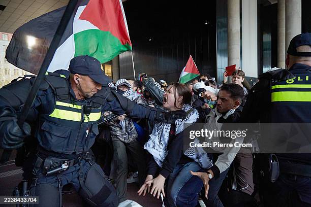 Police officers push back pro-Palestinian activists outside the Dutch Ministry of Foreign Affairs on October 2, 2025 in The Hague, Netherlands. The...