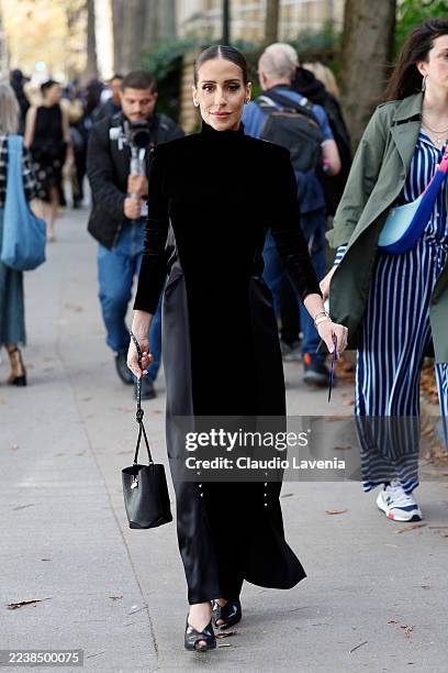 Guest wears black satin and velvet long sleeves turtleneck maxi dress, black heels, black bag, outside Lanvin, during the Womenswear Spring Summer...