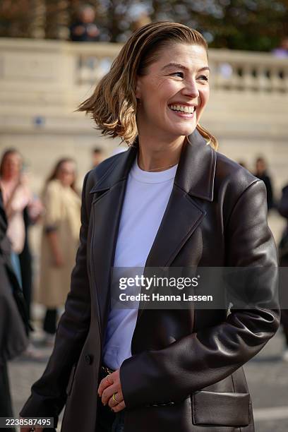 Rosamund Pike is seen wearing white shirt, brown leather jacket, jeans, Dior belt and black bag outside Christian Dior during the Womenswear Spring...