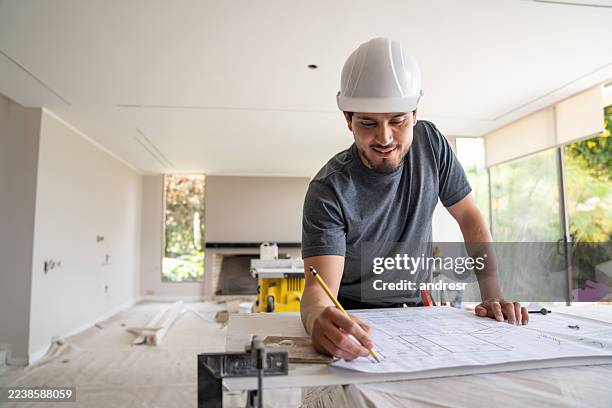 architect drawing on blueprints while remodeling a house - structural engineer stock pictures, royalty-free photos & images