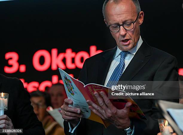October 2025, Saxony-Anhalt, Halle : Federal Chancellor Friedrich Merz stands on the stage during candle singing on the market square in Halle. The...