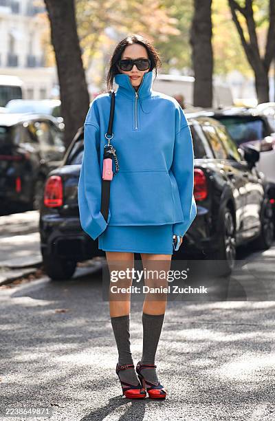 Guest is seen wearing a blue Casablanca outfit, red heels, gray socks and black sunglasses outside the Casablanca show during the Womenswear Spring...
