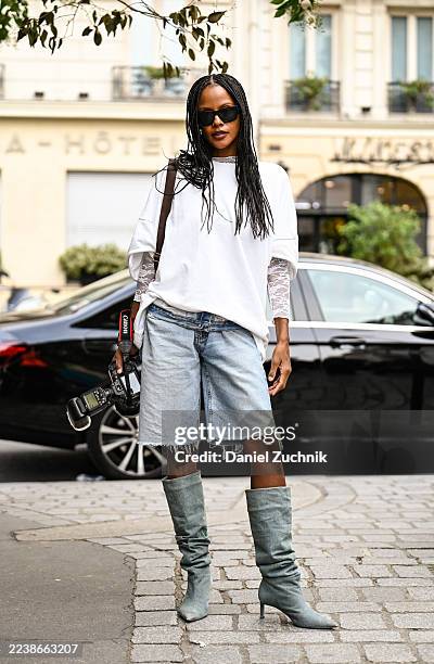 Mary Po is seen wearing a white shirt, laced sleeve top, light blue faded jean shorts, light blue denim boots and black sunglasses outside the Acne...