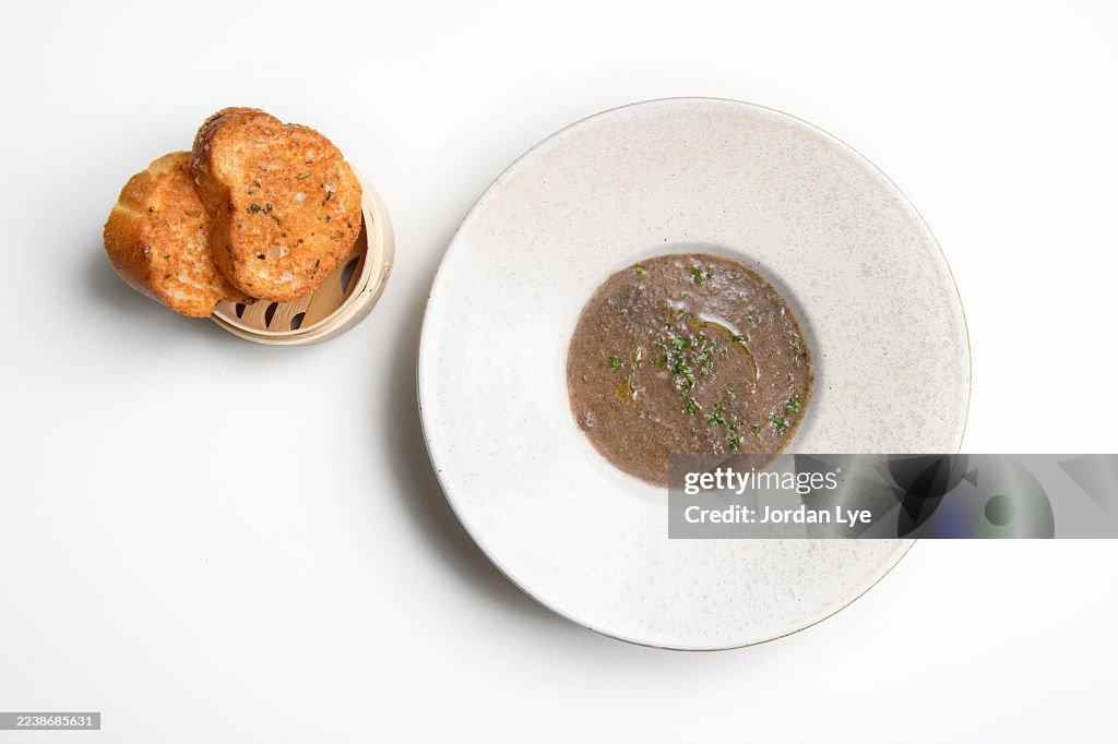 Wild mushroom soup, garnished serve with parsley and grilled slices of bread