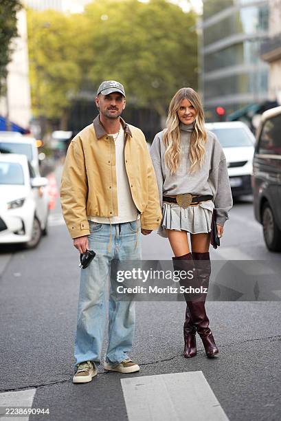 A guest is seen wearing a mustard yellow bomber jacket with a brown collar detail featuring a button-up front and long sleeves; a white crewneck...