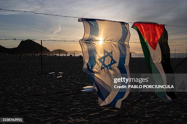 An Israeli and a Palestinian flag hang on an installation set up by members of the Brazilian NGO Rio de Paz at Copacabana beach in Rio de Janeiro,...