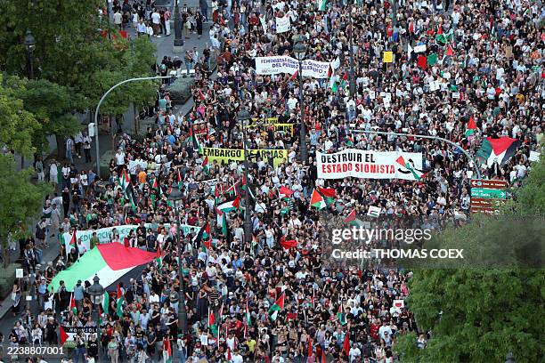 Protesters hold banners and Palestinian banners during a demonstration in solidarity with the Palestinians in the Gaza strip, in Madrid on October 4,...