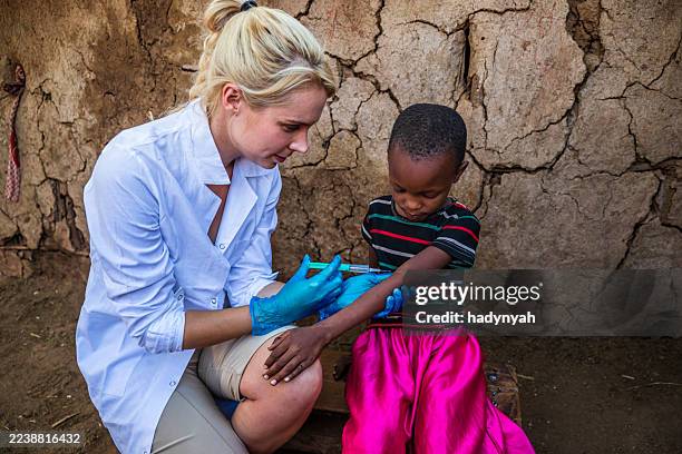 doctor is doing an injection to little african girl in small village, kenya - doctors without borders stock pictures, royalty-free photos & images