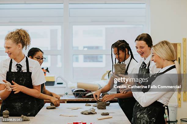 students enjoy a pottery class while creating clay sculptures in a bright art studio - temas fotografías e imágenes de stock
