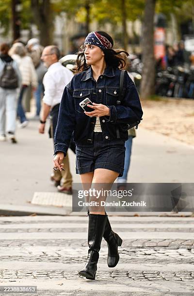 Guest is seen wearing a dark blue jean jacket, jean shorts, black knee high boots and headscarf outside the Carven show during the Womenswear Spring...