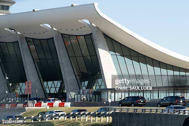The motorcade with US President Donald Trump drives past the main terminal at Dulles International Airport in Dulles, Virginia, October 4, 2025. The...