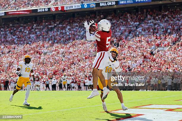 Wide receiver Isaiah Sategna III of the Oklahoma Sooners catches a 30-yard pass for a touchdown against linebacker Canaan Williams of the Kent State...