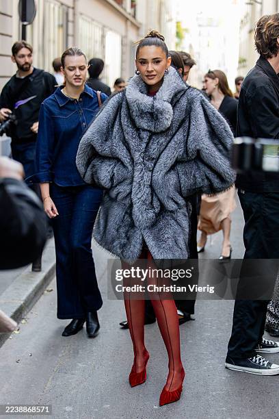 Stefanie Giesinger wears grey fur coat, red tights, heels outside Mugler during the Womenswear Spring Summer 2026 as part of Paris Fashion Week on...