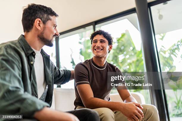 father and son talking at home - teen son stock pictures, royalty-free photos & images